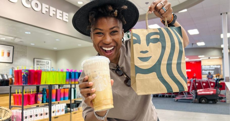 woman holding up starbucks bag and big starbucks drink