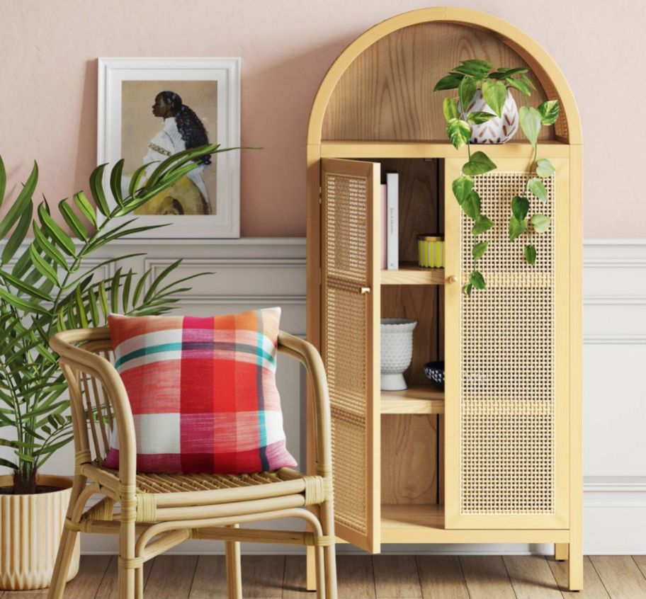 a wicker cabinet next to a wicker chair in an entryway