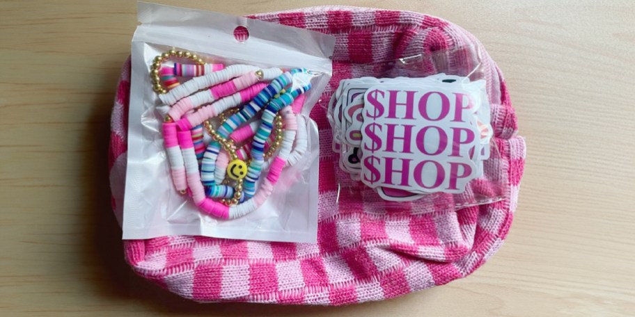 pink checkered makeup bag with stickers and bracelets 