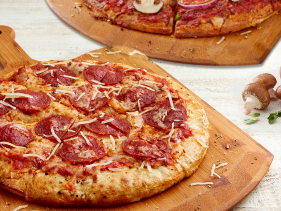 2 pizzas on wooden boards