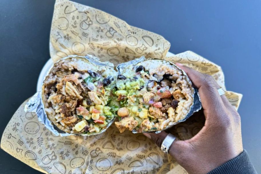 hand holding a Chipotle Burrito on a paper wrapper