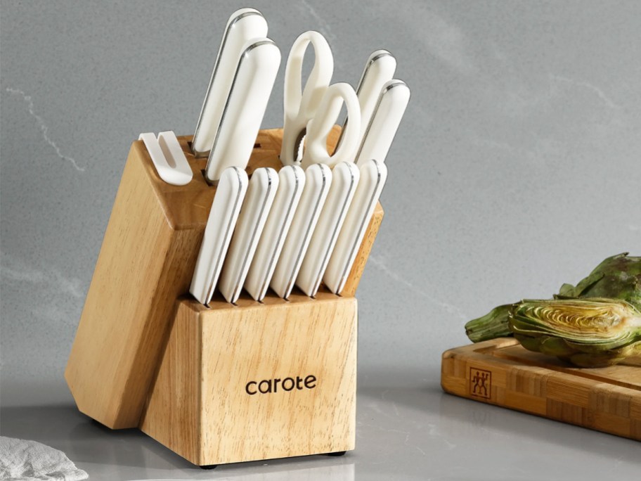 white kitchen knives in a wood block on a counter