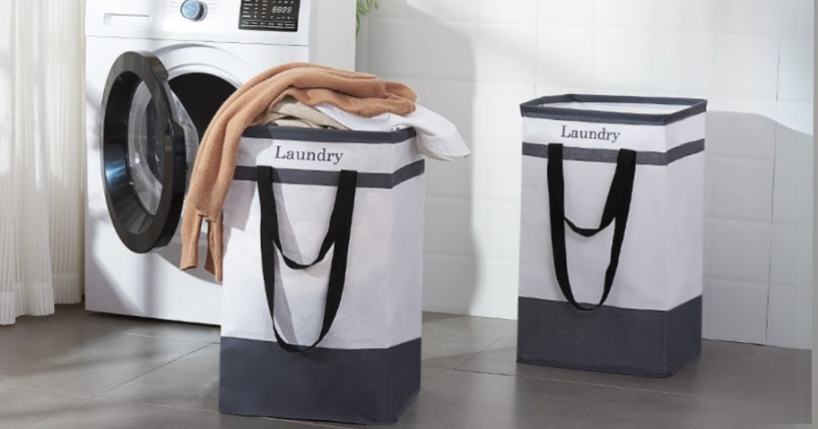 two white and black Laundry baskets in a laundry room next to a washing machine, one has clothing spilling out of it