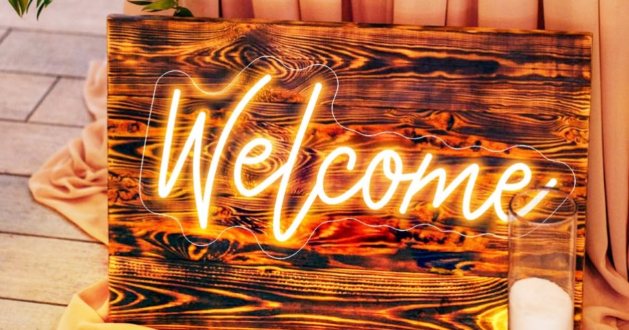 led sign on a wood board that says "welcome"