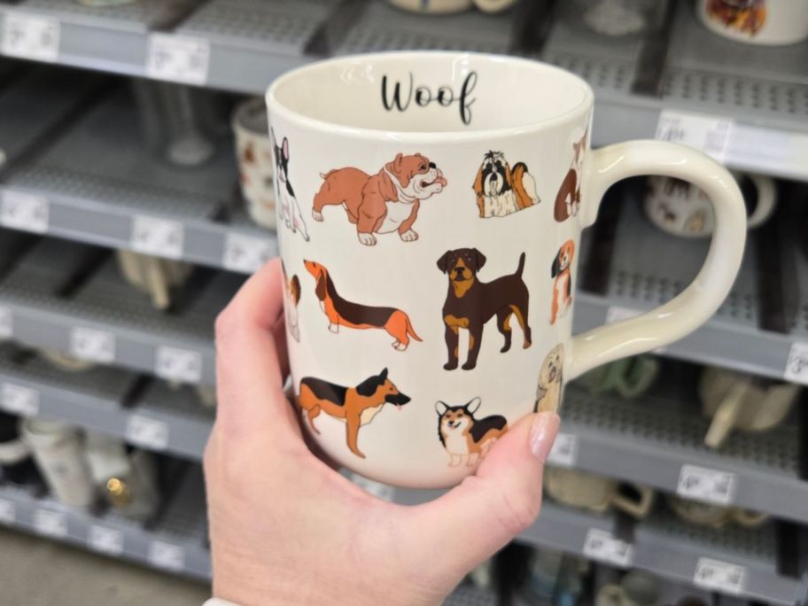 A person holding a mug with dogs on it 