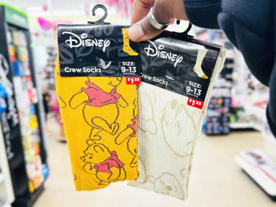 hand holding up two pairs of Disney Winnie The Pooh Crew Socks