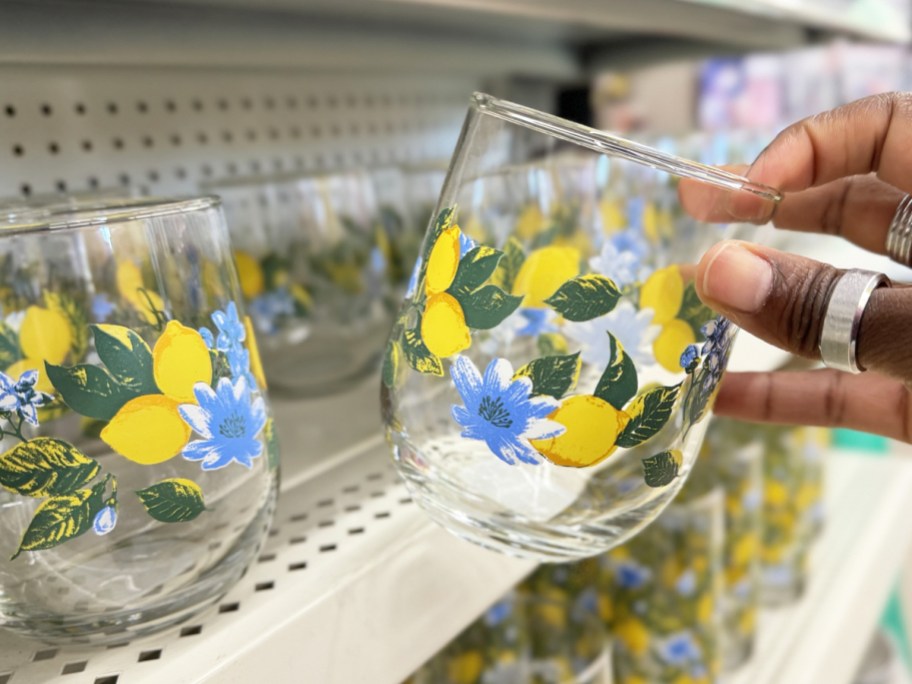 hand holding up a lemon print stemless wine glass