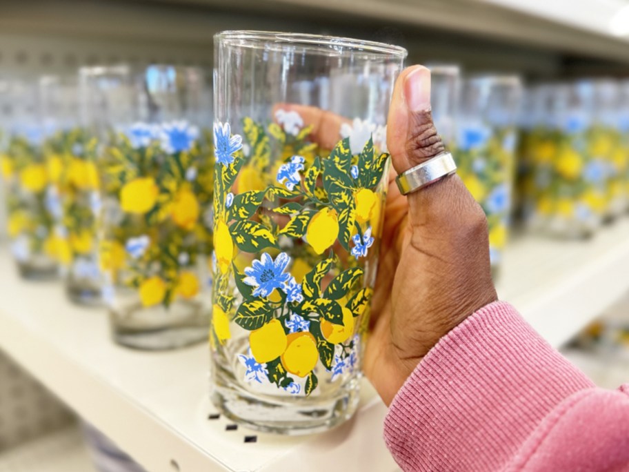 hand holding up a lemon print drinking glass