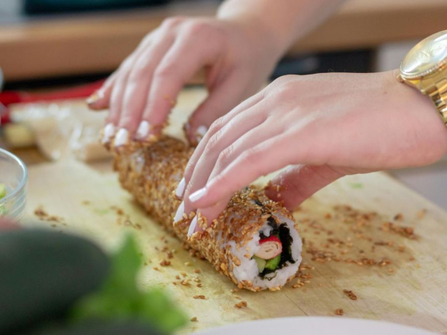 Hands rolling sushi