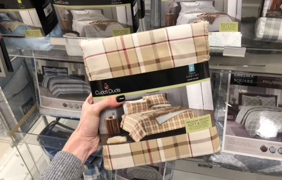 a womans hand holding a set of mcrofiber sheets