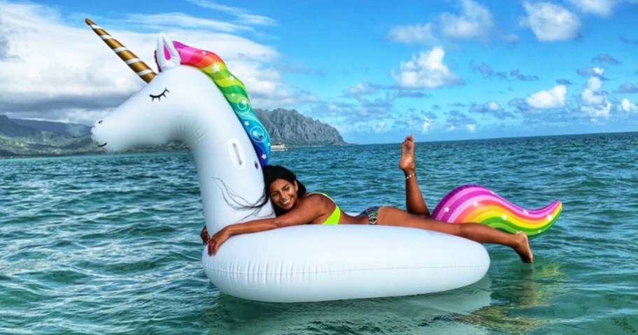 woman floating on a giant inflatable unicorn pool float