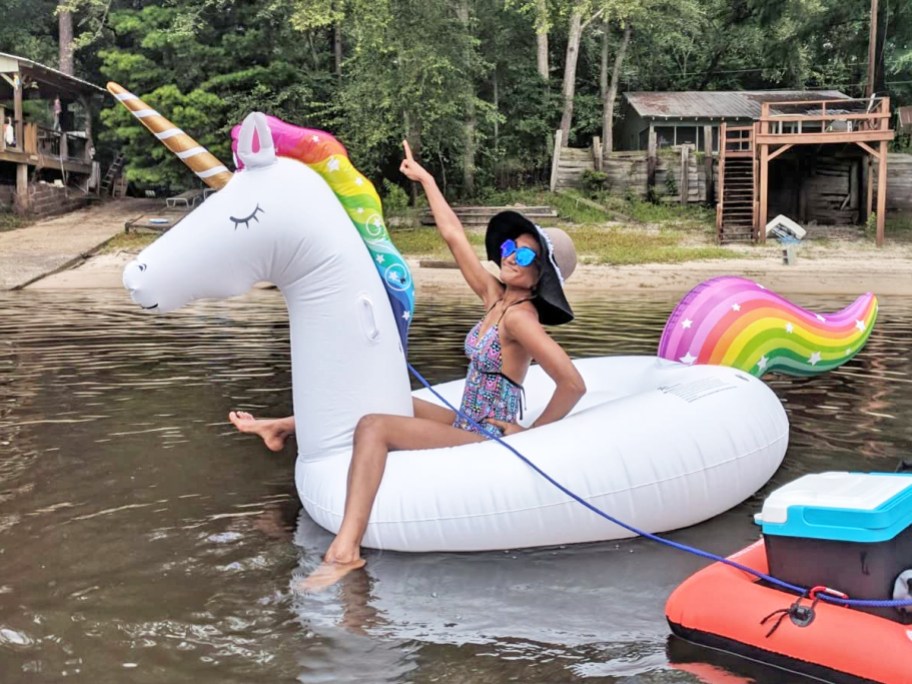 woman floating on a giant inflatable unicorn pool float