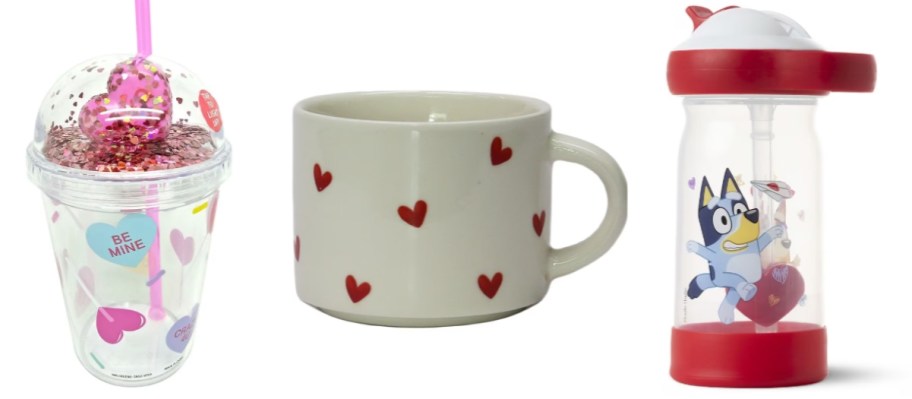 a clear plastic cup with a dome lid and straw that has Valentine's Sweethearts Candy hearts on it, a cream color coffee mug with red hearts, and a kid's Bluey Valentine's themed water bottle