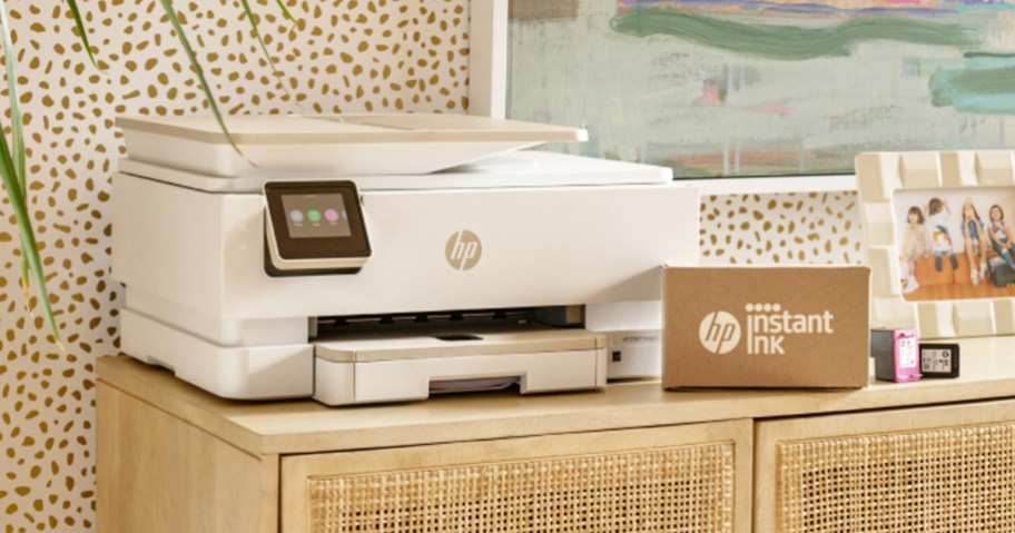 white printer with box of HP instant ink in front of it