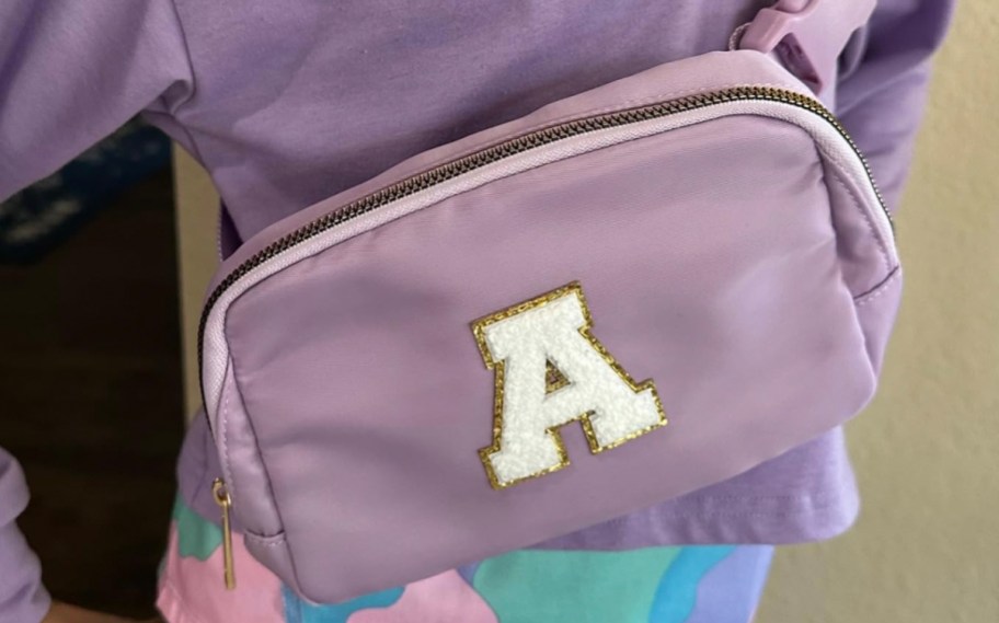 child wearing purple letter A inital belt bag