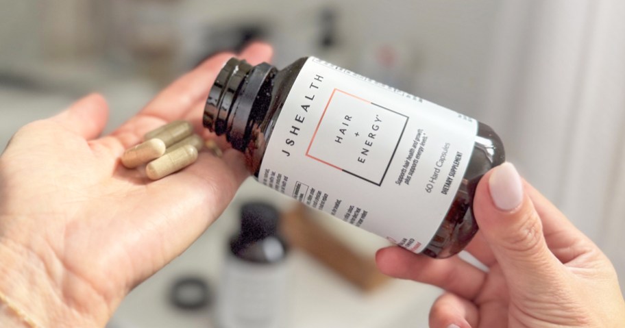 woman pouring a bottle of JSHealth Vitamins Hair + Energy supplement into her hands