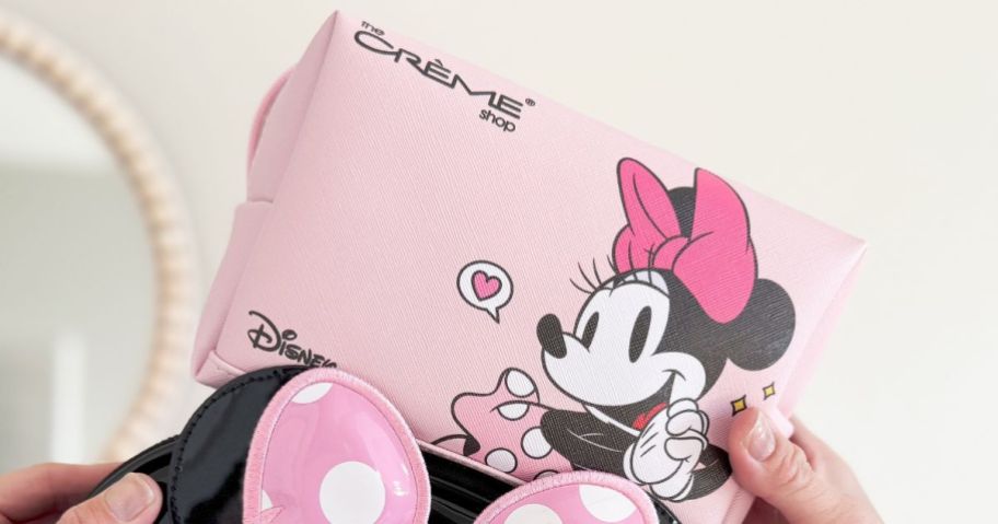 A person holding a Minnie Mouse travel cosmetics bag