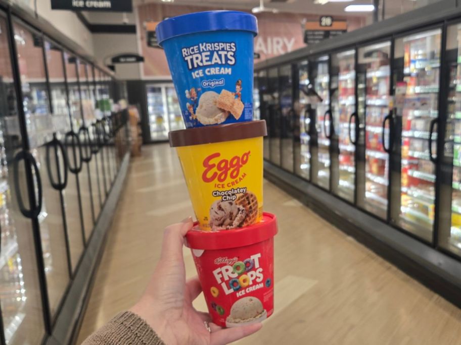 A hand holding Cereal Bar Ice Cream Pints 