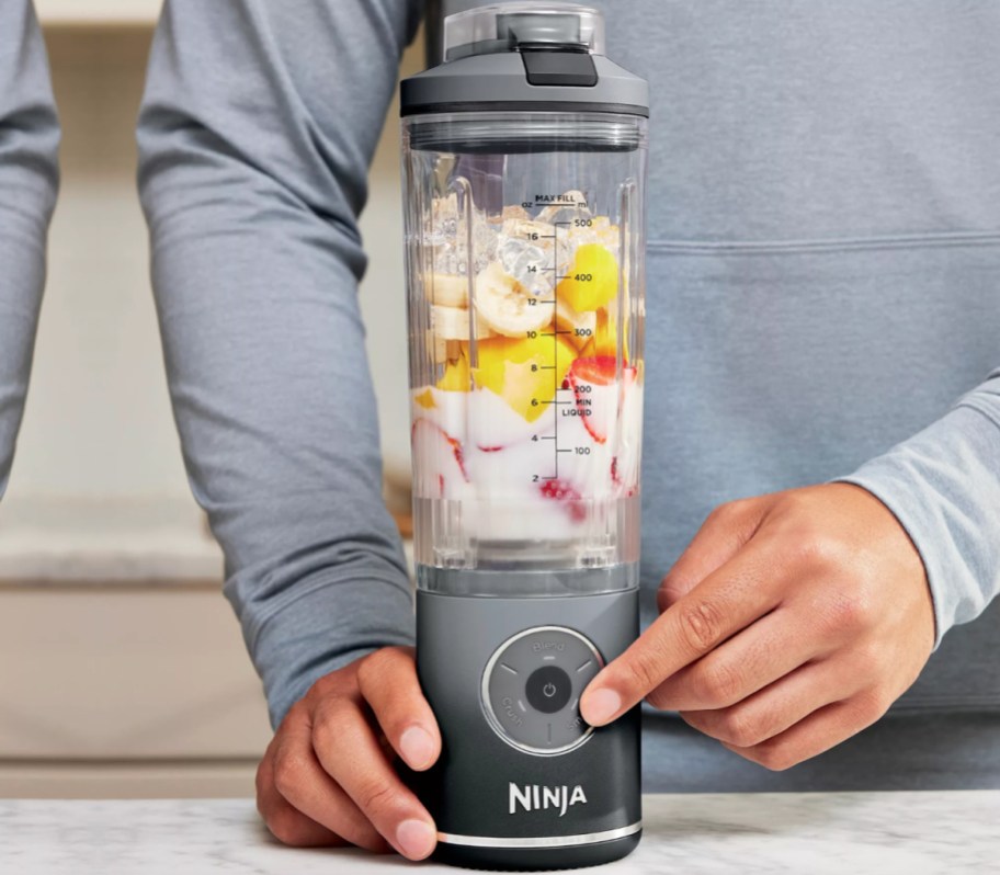 hand pushing ninja blender button