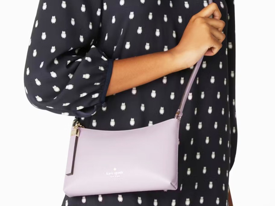 woman in an owl print dress with a light purple crossbody bag