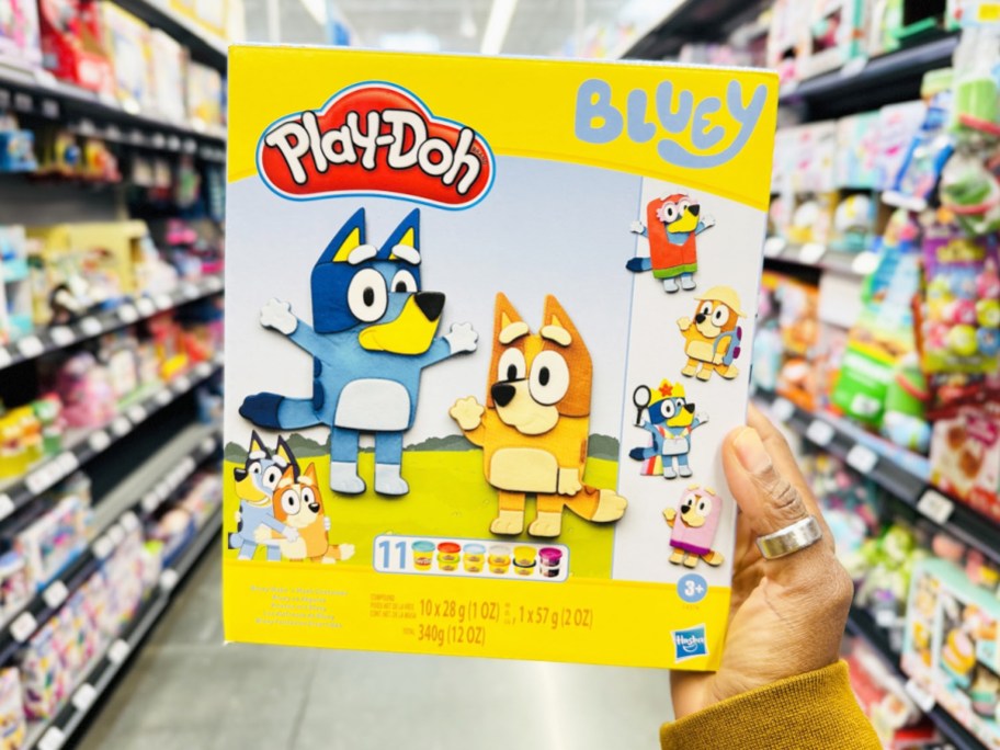 hand holding up Play-Doh Bluey Make 'n Mash Costumes Playset box in store