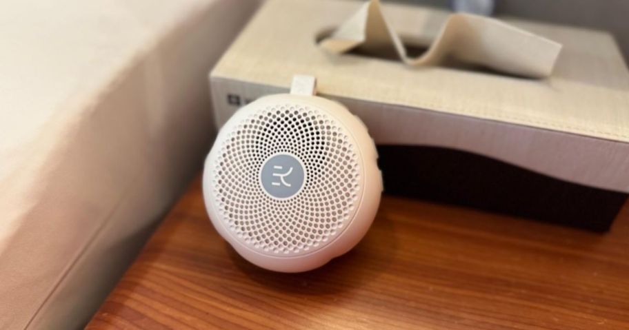 A white noise machine on a bedside table 