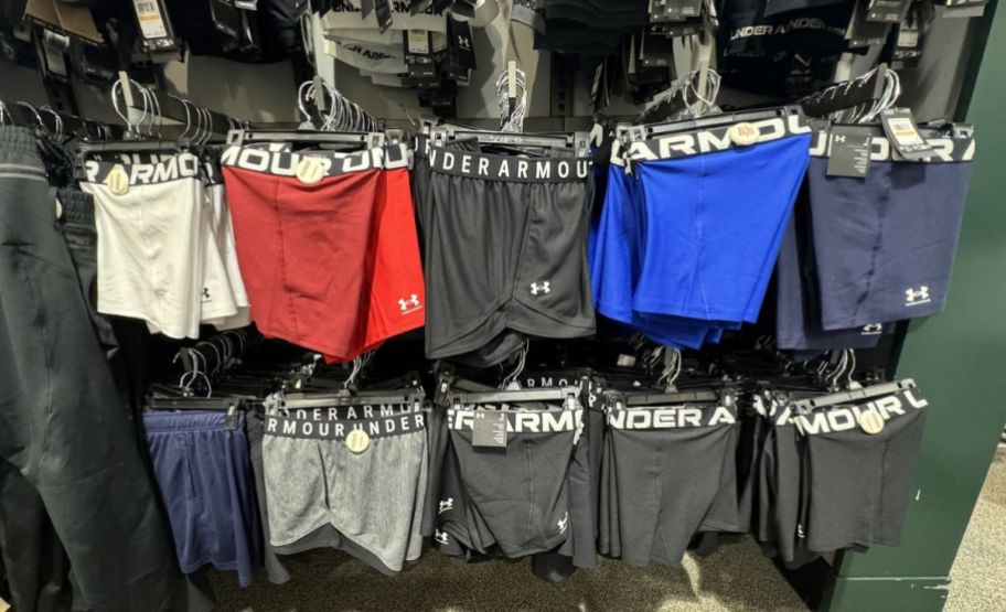 under armour shorts hanging on a wall rack in a store