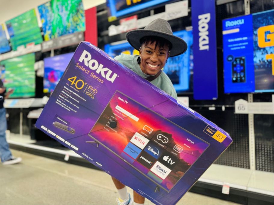 person holding Roku 40" Select Series 1080p Full HD Smart Roku TV box in store