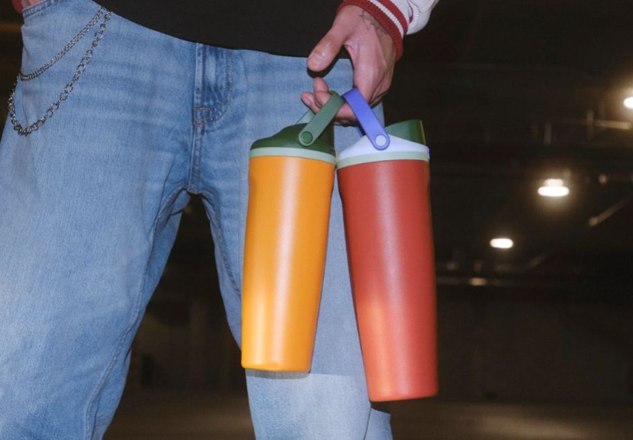 a person shown holding 2 owala water bottles by the top handles