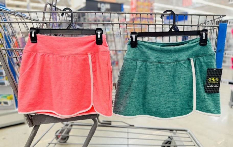 2 activewear skorts hanging on the side of a cart in a store