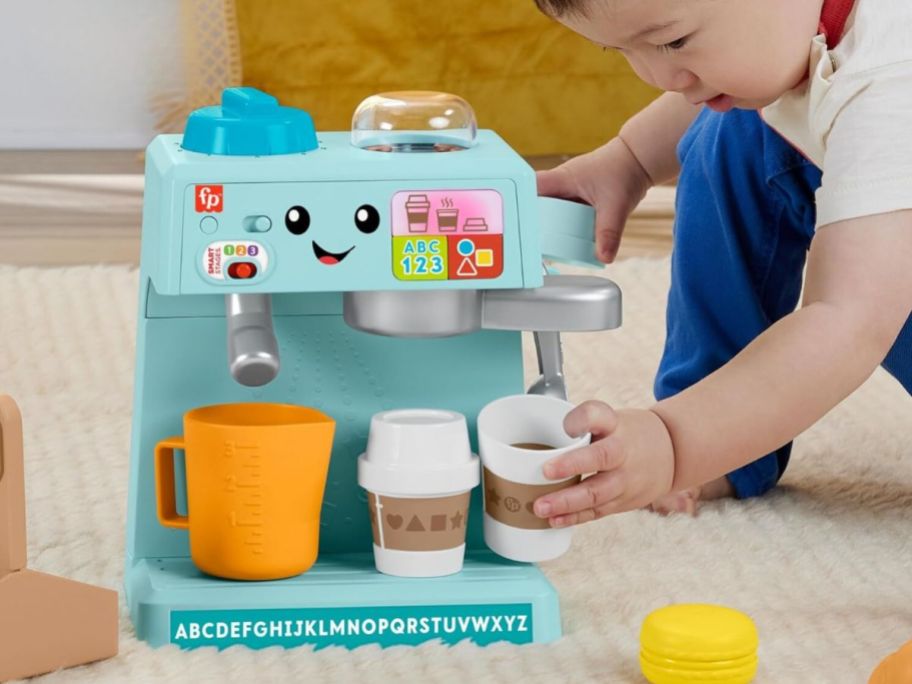 kid playing with Fisher-Price Laugh & Learn & Serve Coffee Cafe Playset