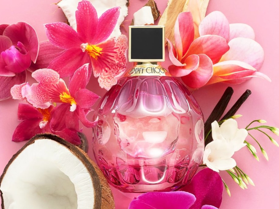 pink bottle of Jimmy Choo Rose Passion surrounded by pink flowers and coconut