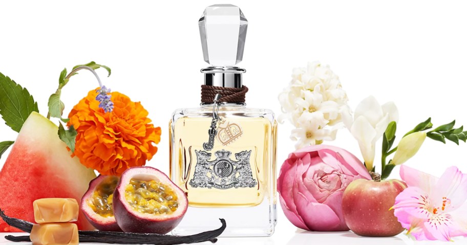 bottle of Juicy Couture EDP Spray surrounded by flowers and fruits