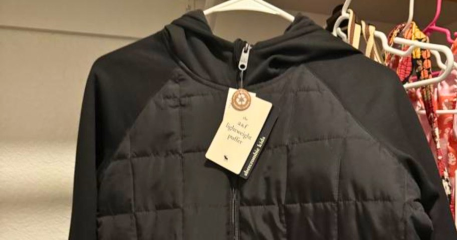 a black kid's Abercrombie & Fitch Jacket hanging on a <a href='https://exquisica.com/abstract-style-modern-led-wall-lamp' target='_blank' rel='follow'>wall</a> display – the tag is still attached” width=”912″ height=”479″></p>
<p>For a limited time, head over to <a href=