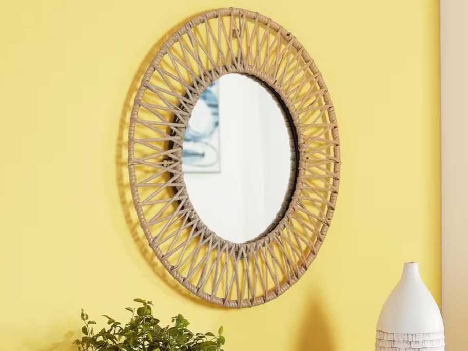 round wall mirror on yellow wall