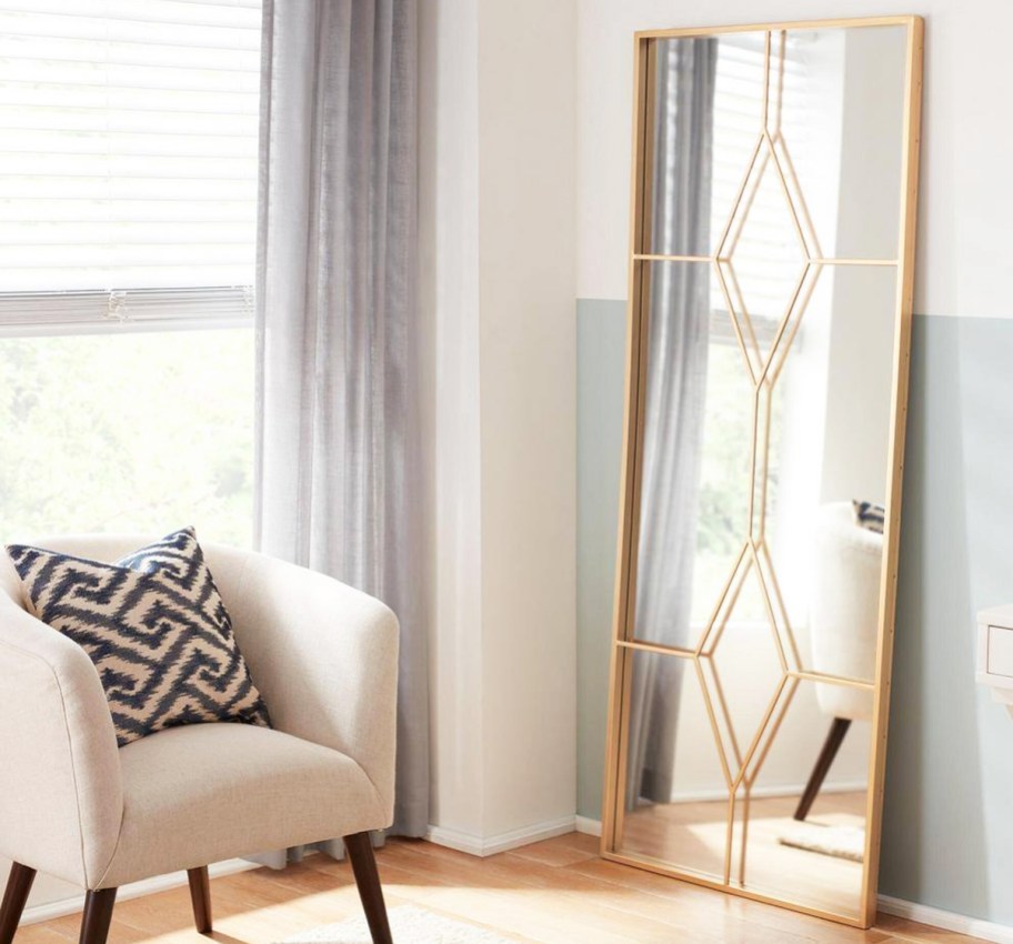 gold framed windowpane floor mirror near accent chair