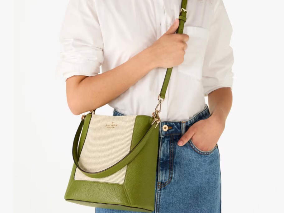 woman holding green tote crossbody 