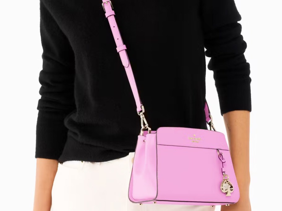 woman in a black sweater with a pink crossbody bag