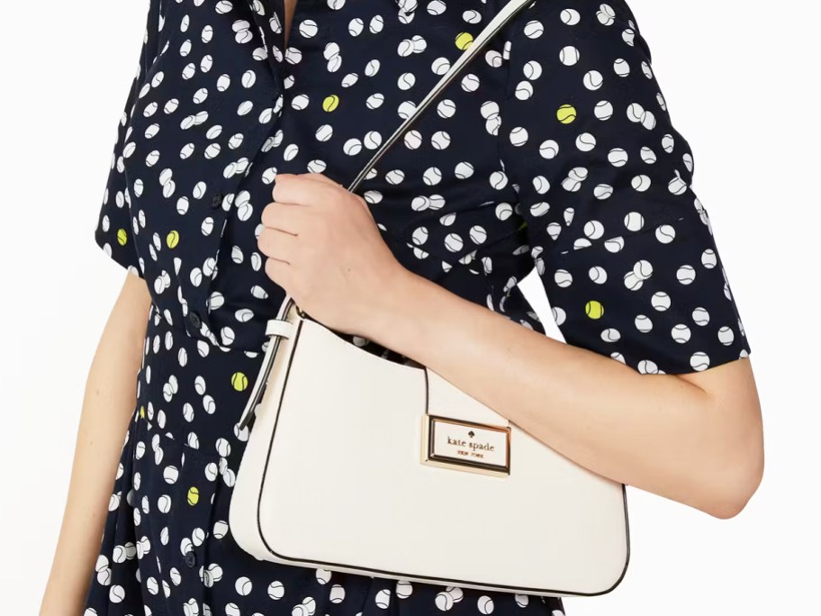 woman in a polka dot dress with white shoulder bag