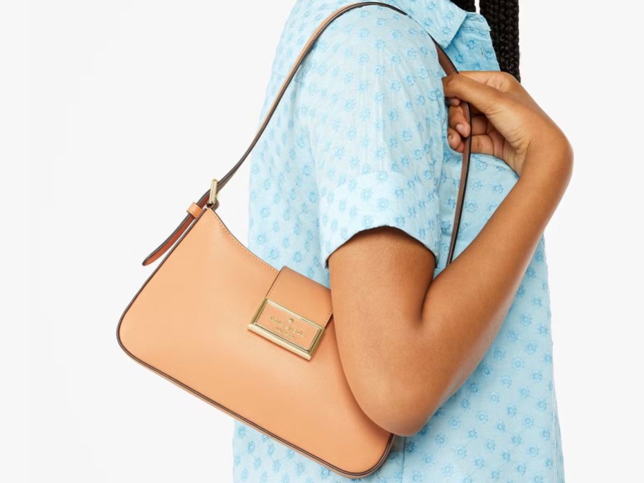 woman wearing tan kate spade bag 