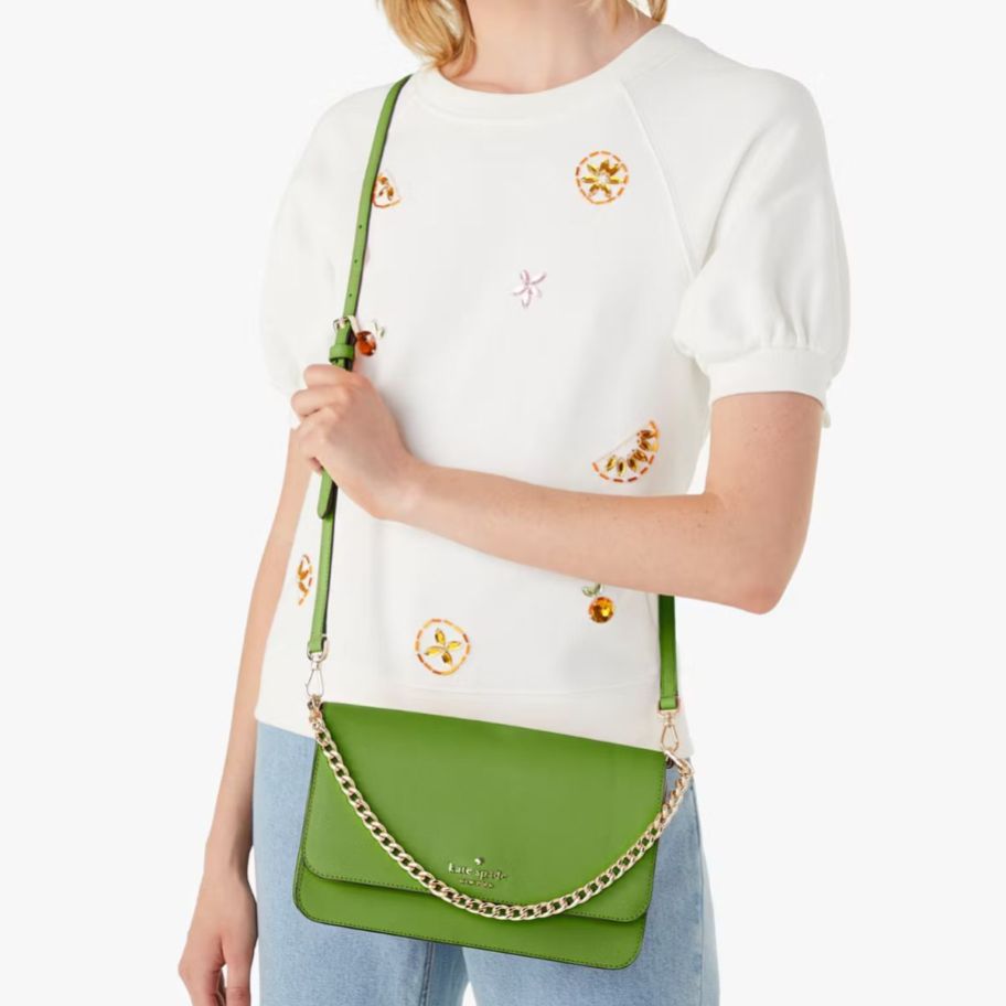 a woman with a green crossbody handbag