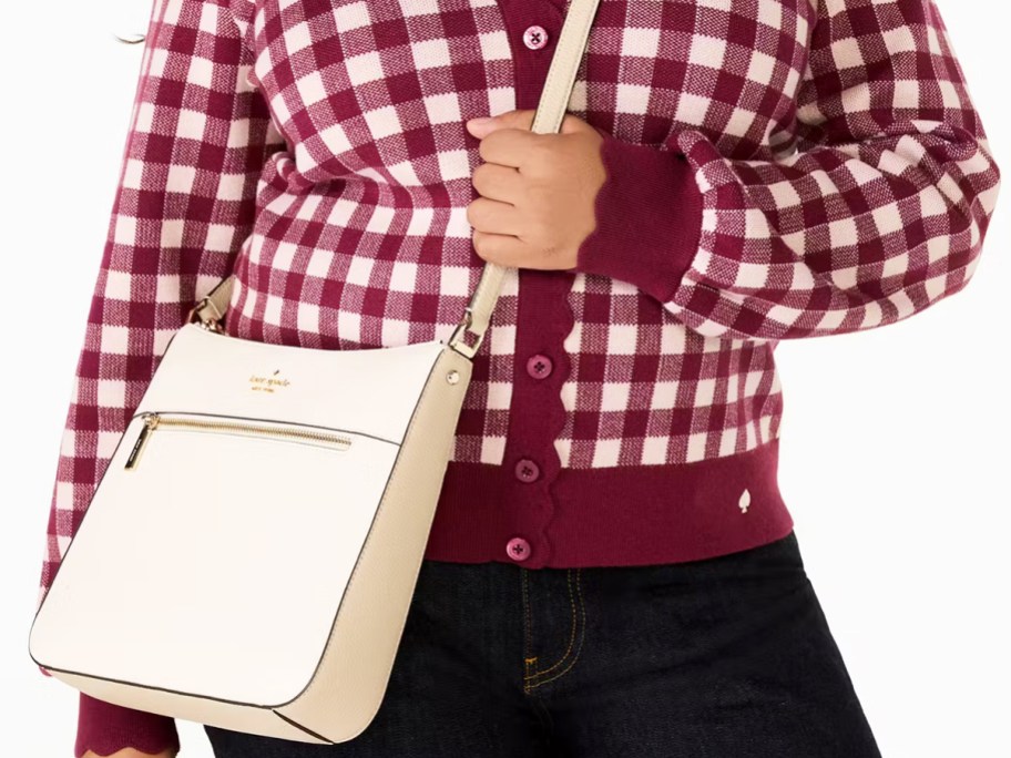 woman in a maroon plaid sweater with large white crossbody bag