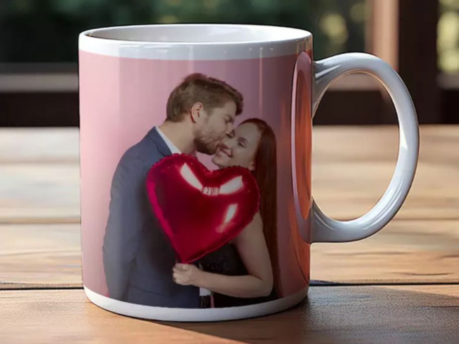 A photo mug with a man kissing a woman holding a heart-shaped red balloon