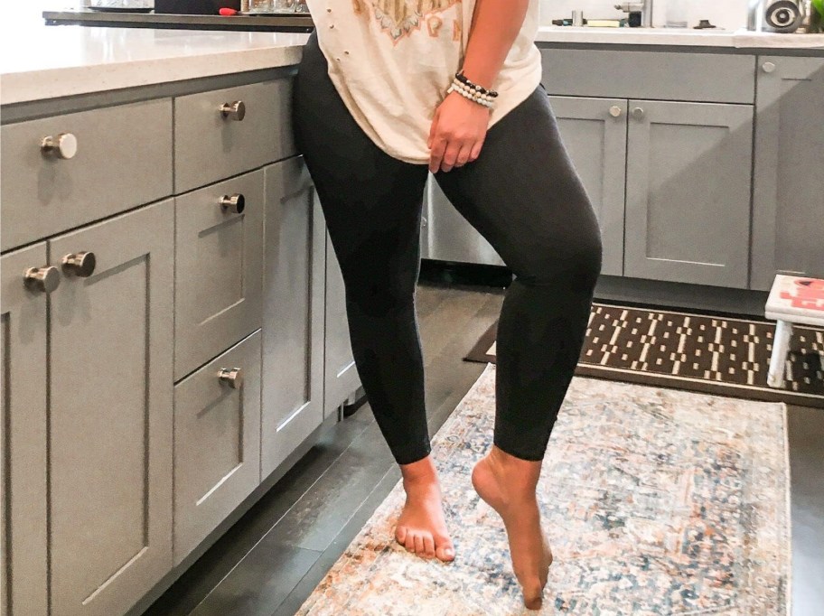 woman standing in kitchen wearing black plus size leggings 