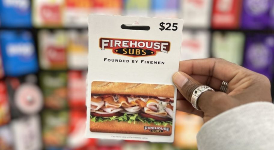 a womans hand holding a firehouse subs gift card