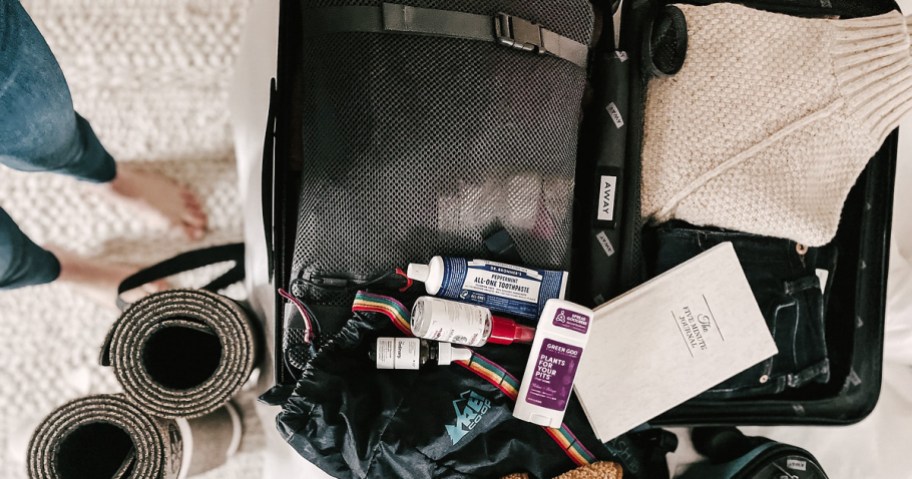 suitcase with various toiletries on top for travel packing hacks