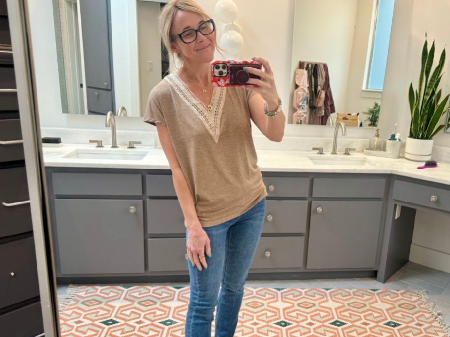 woman taking selfie in tan shirt and jeans