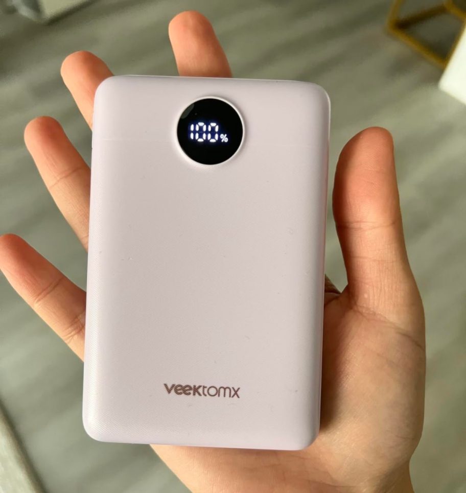 hand holding a light pink power bank