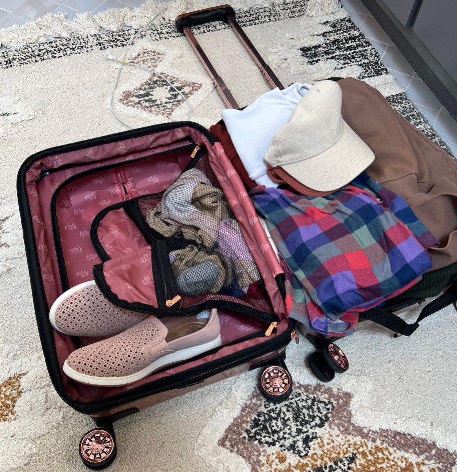 ifly luggage suitcase laying on rug filled with clothes