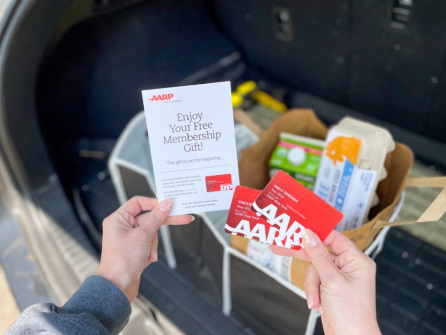 woman holding up aarp cards and showing free trunk organizer